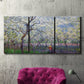 Three-panel canvas wall art featuring fresh spring countryside landscape, displayed in a living room above a suede accent chair.