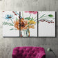 Three-panel canvas wall art featuring vibrant floral bouquet, displayed in a living room above a suede accent chair.