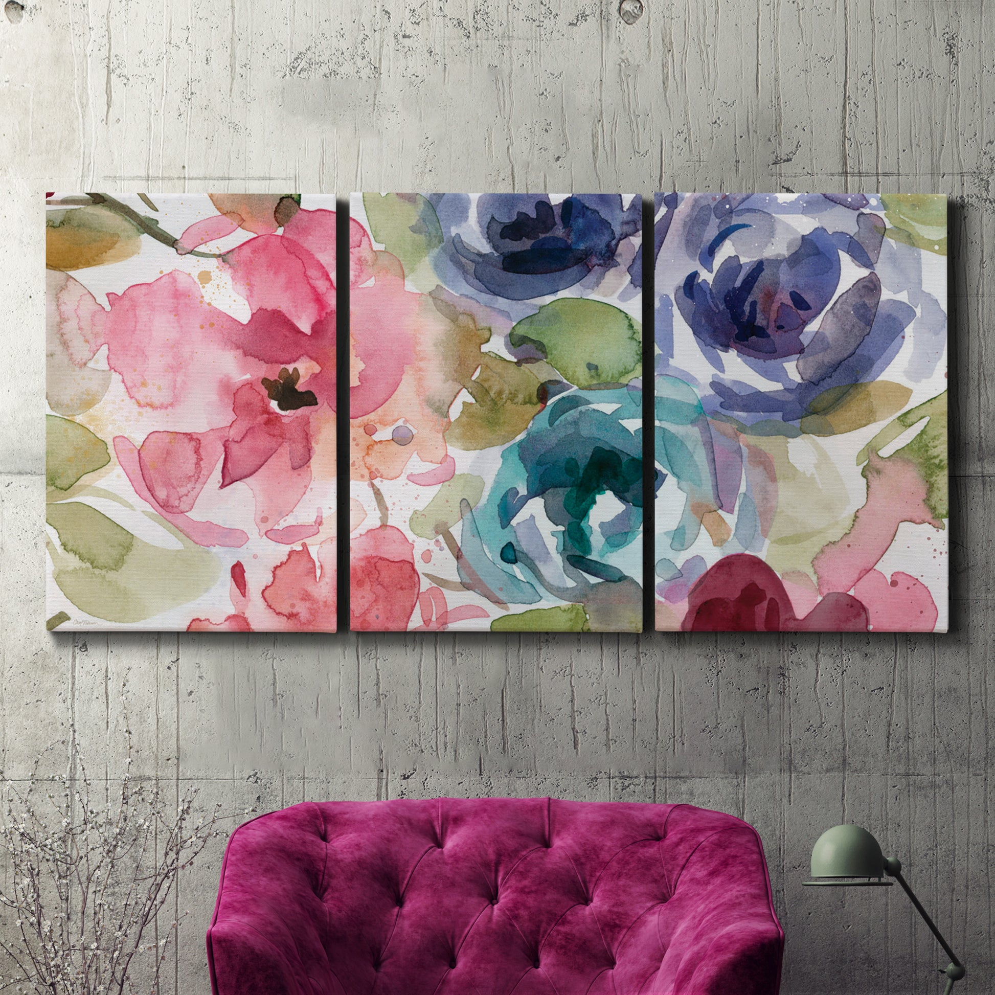 Three-panel canvas wall art featuring soft floral watercolor composition, displayed in a living room above a suede accent chair.