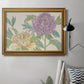 Contemporary peony flower illustration in an ornate traditional gold frame displayed in a neutral interior setting.