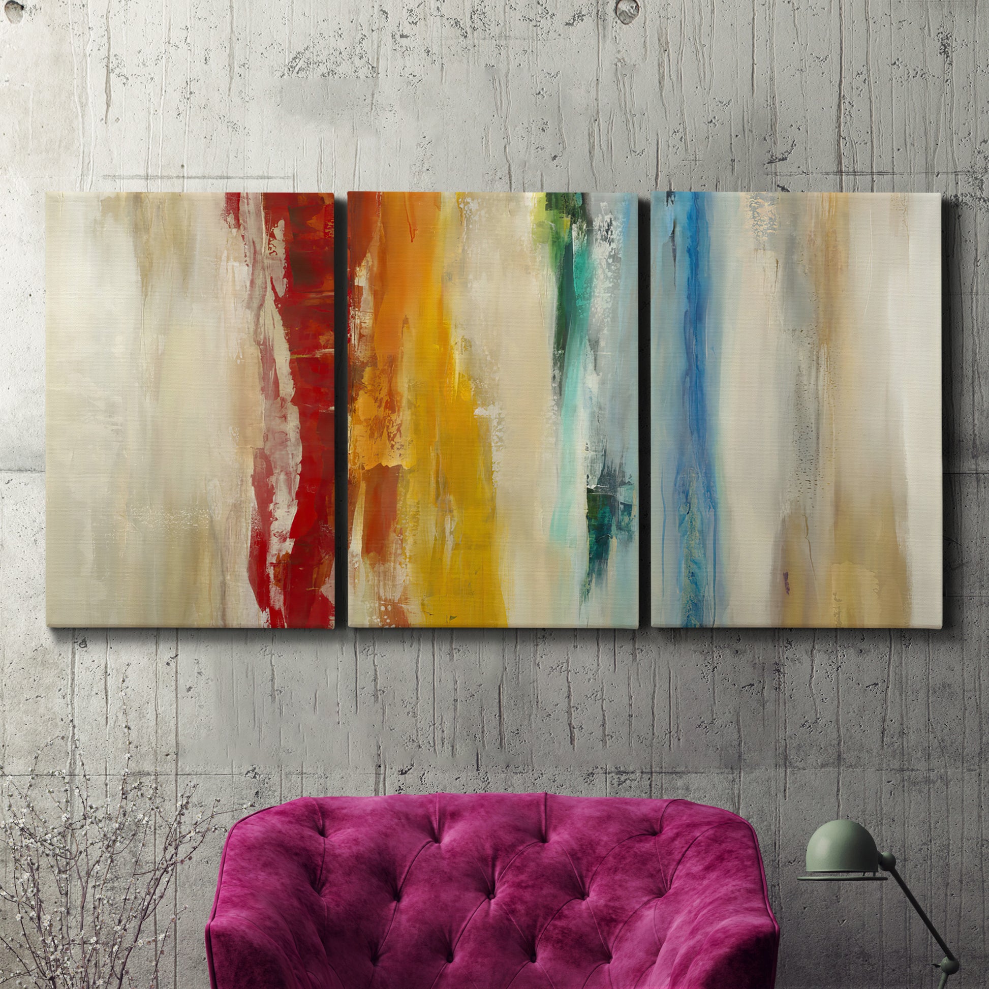 Three-panel canvas wall art featuring abstract divided color hemisphere forms, displayed in a living room above a suede accent chair.