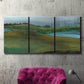 Three-panel canvas wall art featuring quiet contemplative landscape scene, displayed in a living room above a suede accent chair.