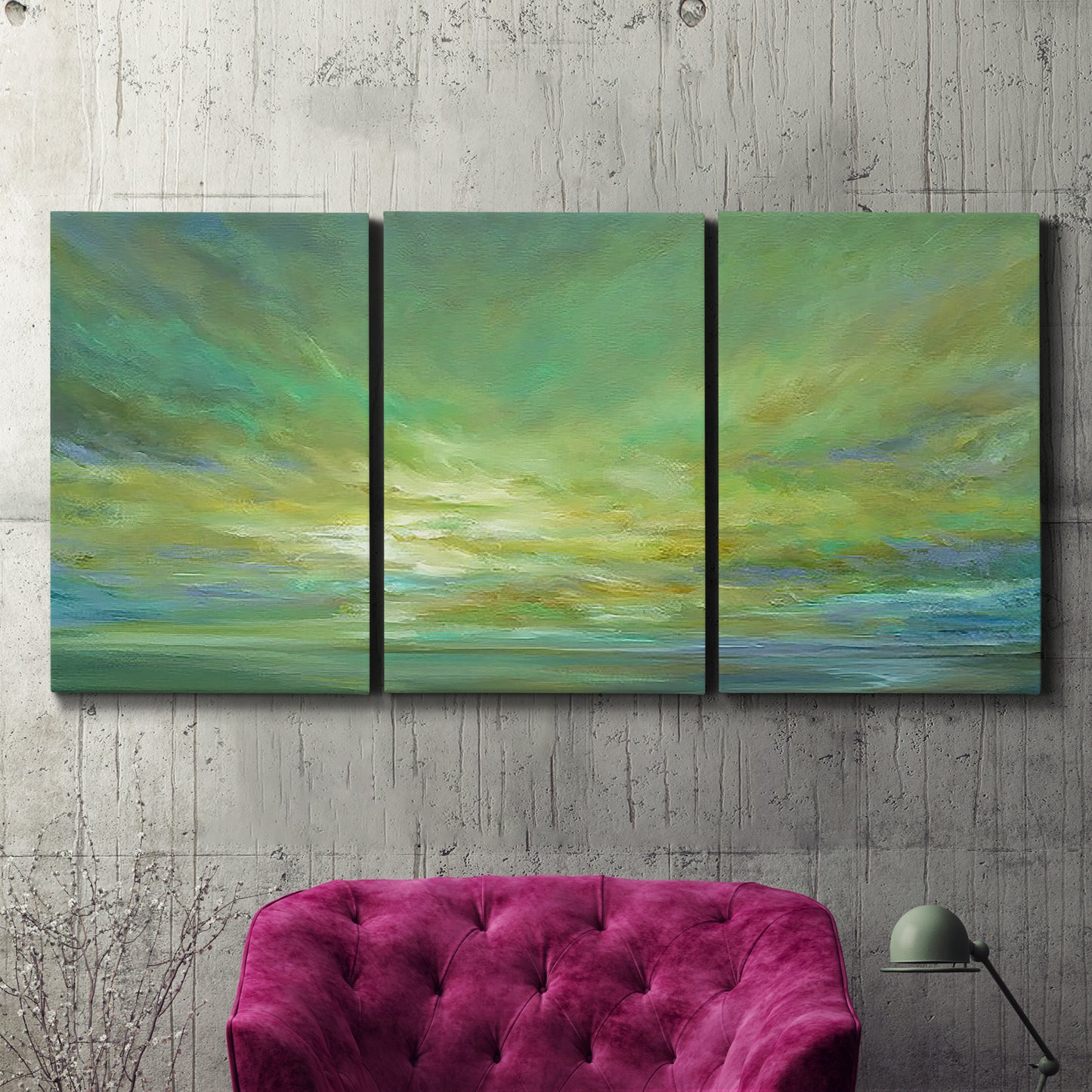 Three-panel canvas wall art featuring coastal shoreline under open sky, displayed in a living room above a suede accent chair.