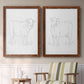 Set of two maple barnwood framed canvas prints depicting two minimalist livestock sketches featuring simple contour drawings of standing cows above a sideboard in a cozy sitting room.