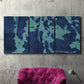 Three-panel canvas wall art featuring abstract floral shapes, displayed in a living room above a suede accent chair.