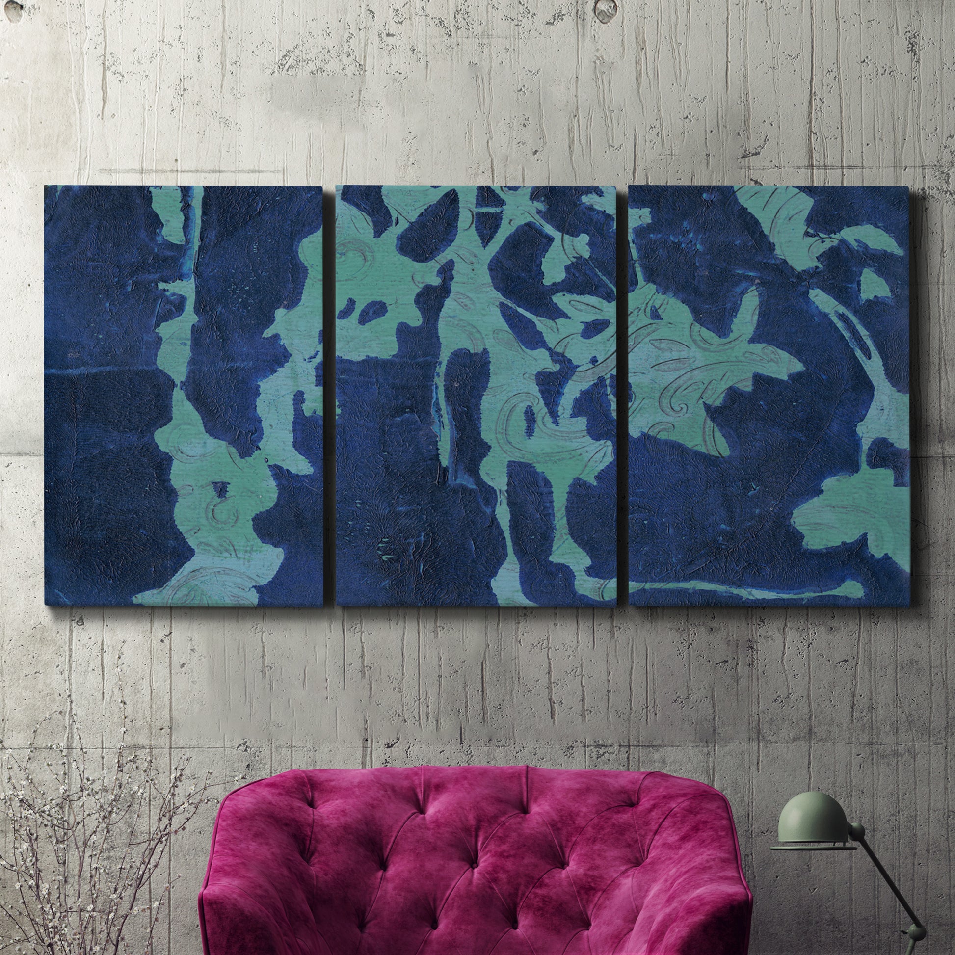 Three-panel canvas wall art featuring abstract floral shapes, displayed in a living room above a suede accent chair.