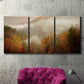 Three-panel canvas wall art featuring misty autumn landscape photograph, displayed in a living room above a suede accent chair.