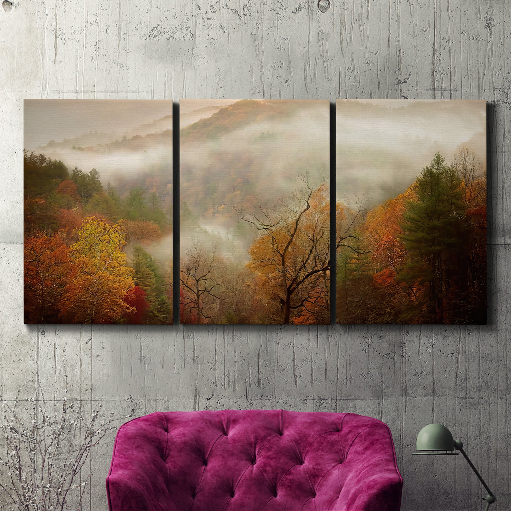 Three-panel canvas wall art featuring misty autumn landscape photograph, displayed in a living room above a suede accent chair.