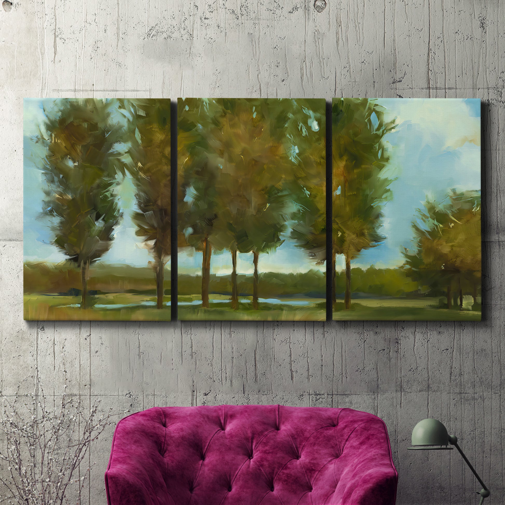 Three-panel canvas wall art featuring tall trees lining open landscape, displayed in a living room above a suede accent chair.