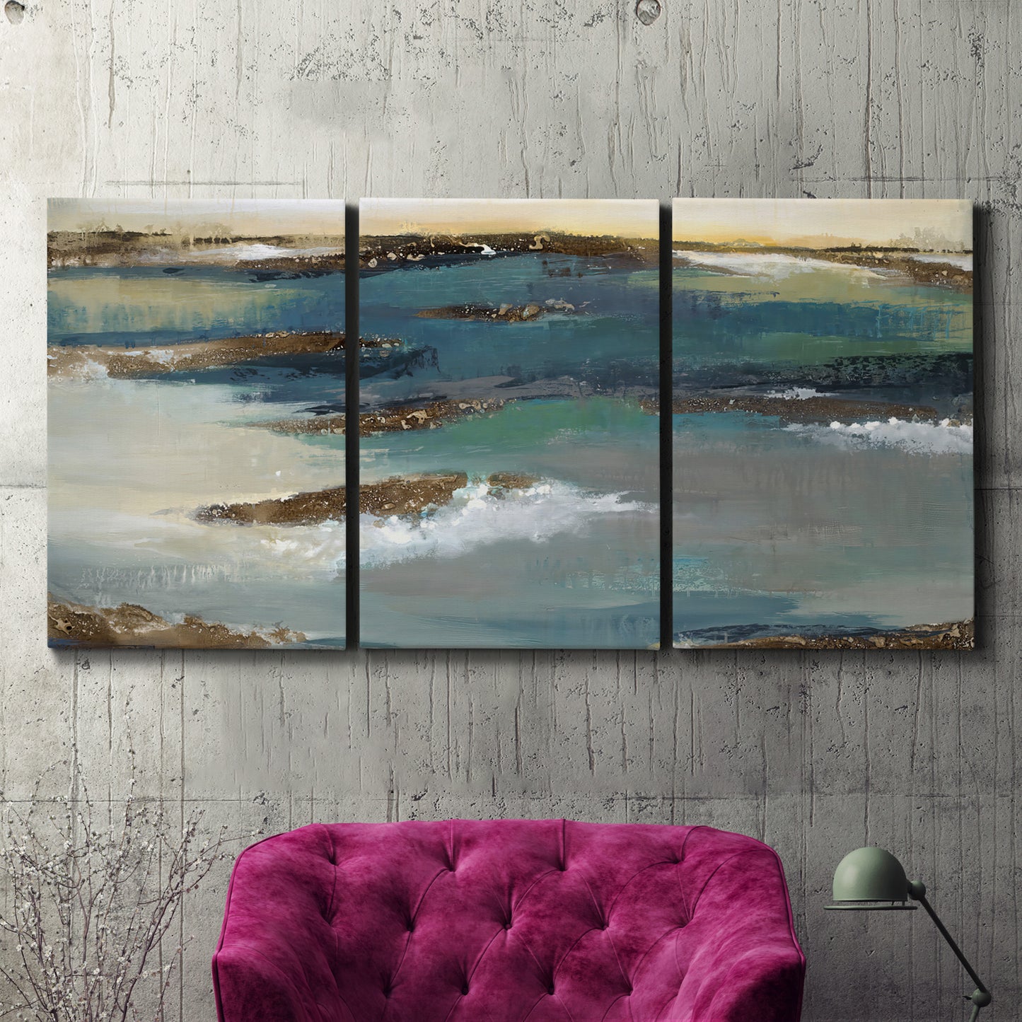 Three-panel canvas wall art featuring rocky coastal bluff above sea, displayed in a living room above a suede accent chair.