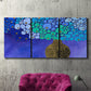 Three-panel canvas wall art featuring blue poppy floral abstraction, displayed in a living room above a suede accent chair.