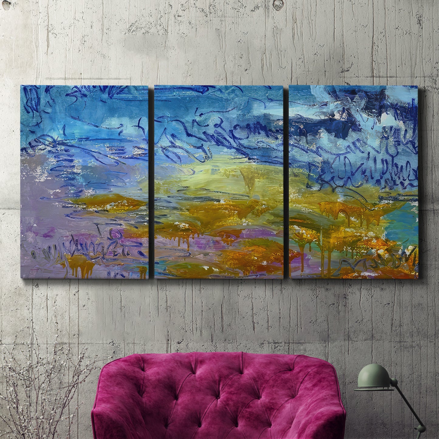 Three-panel canvas wall art featuring expressive abstract with layered color, displayed in a living room above a suede accent chair.