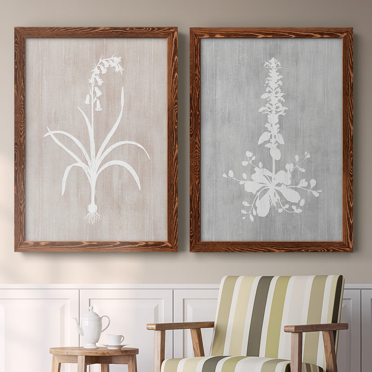 Set of two maple barnwood framed canvas prints depicting two rustic minimalist botanical prints featuring white botanical silhouettes on softly weathered neutral backgrounds above a sideboard in a cozy sitting room.