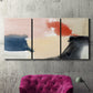 Three-panel canvas wall art featuring playful abstract watercolor shapes, displayed in a living room above a suede accent chair.