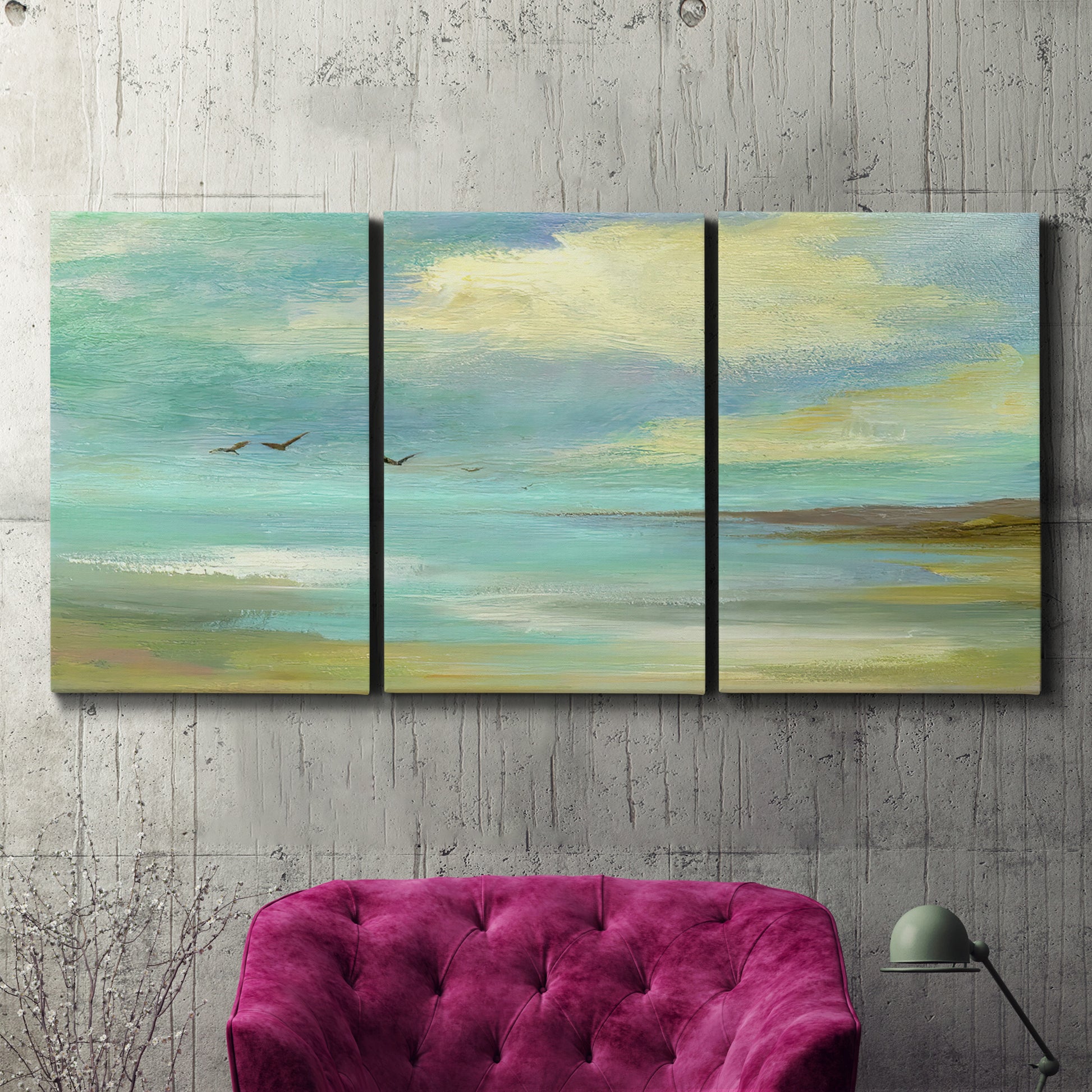 Three-panel canvas wall art featuring calm coastal drift patterns, displayed in a living room above a suede accent chair.