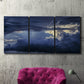 Three-panel canvas wall art featuring hot air balloons rising at dawn, displayed in a living room above a suede accent chair.