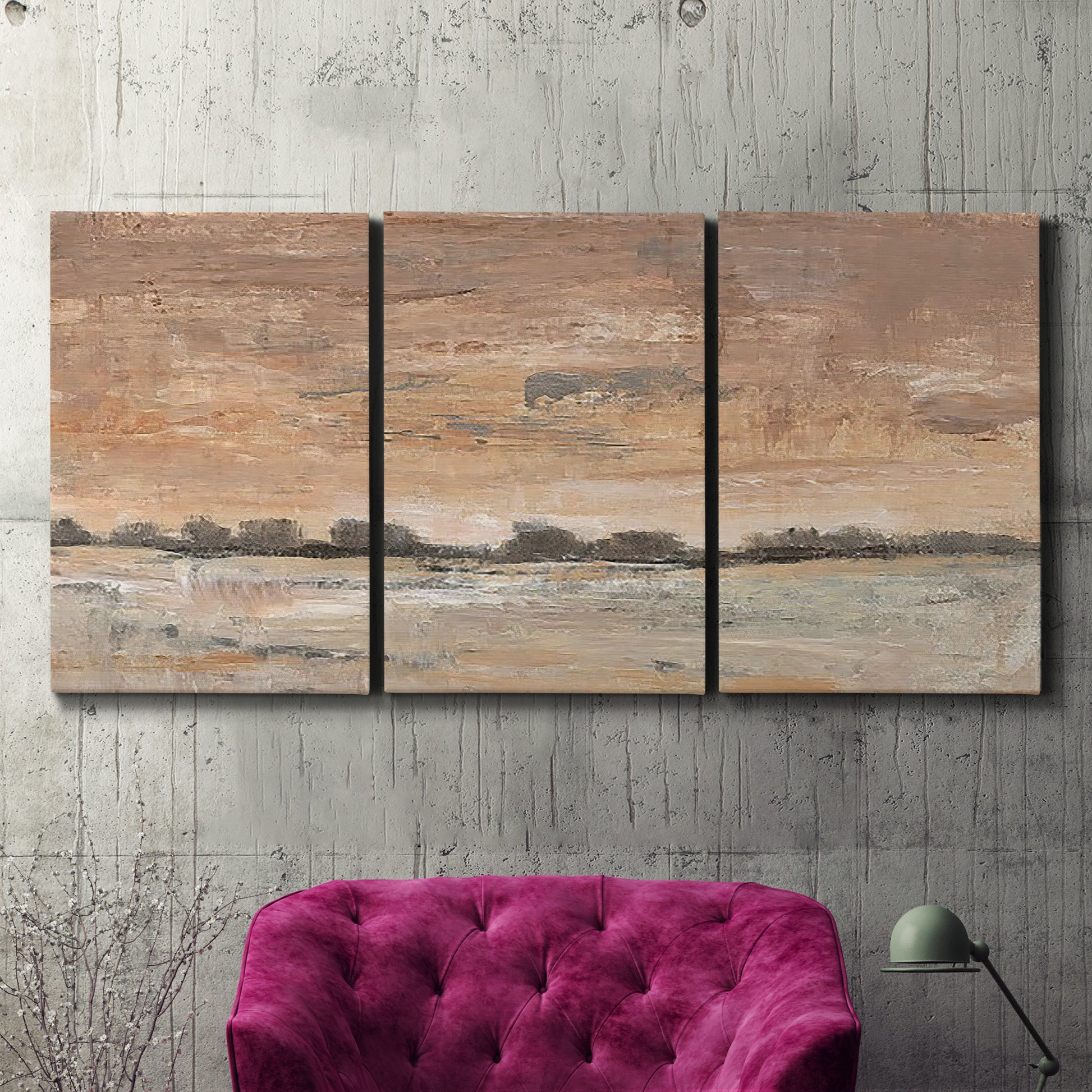 Three-panel canvas wall art featuring soft early evening landscape light, displayed in a living room above a suede accent chair.