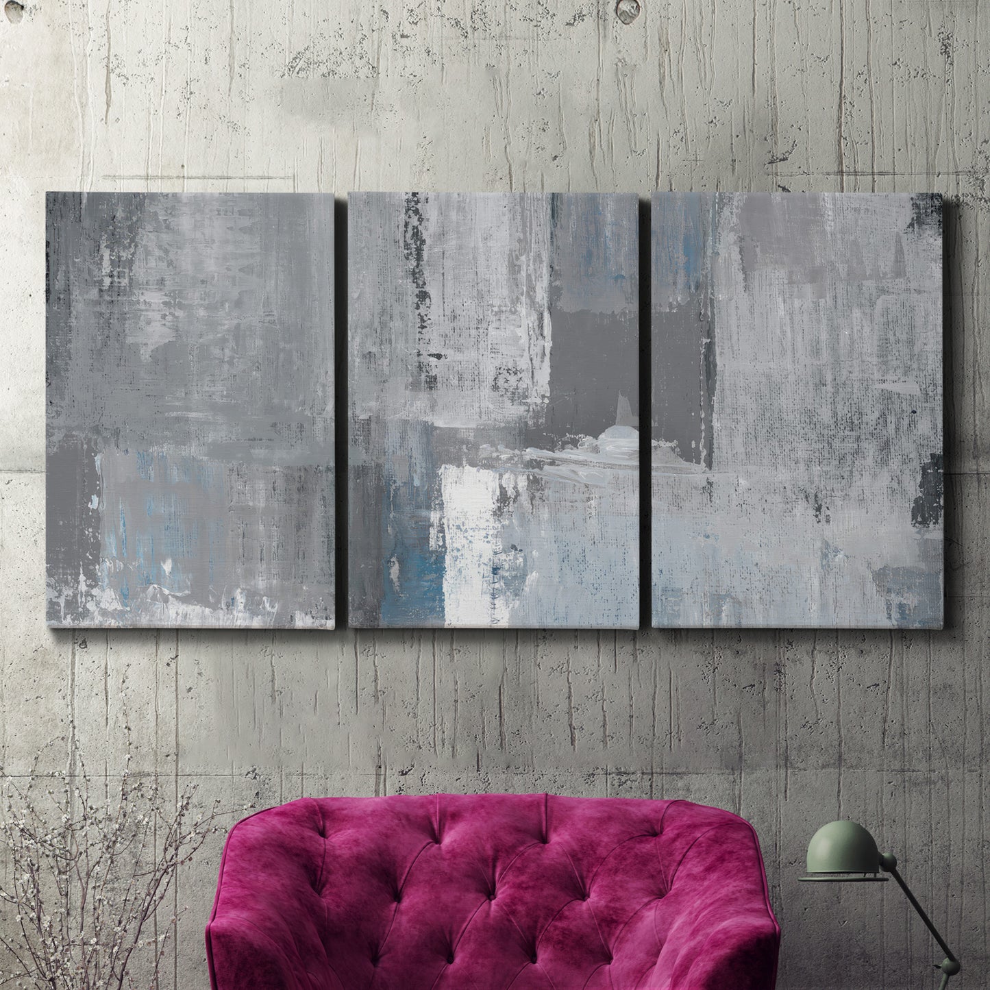 Three-panel canvas wall art featuring cool toned industrial abstract blues, displayed in a living room above a suede accent chair.