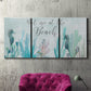 Three-panel canvas wall art featuring coastal typography with seahorses, displayed in a living room above a suede accent chair.