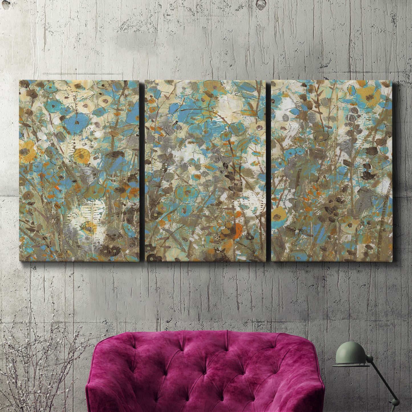 Three-panel canvas wall art featuring abstract flowering vine pattern, displayed in a living room above a suede accent chair.