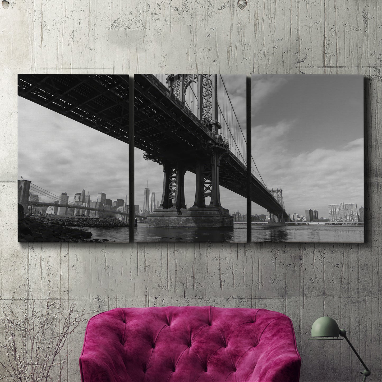 Three-panel canvas wall art featuring manhattan bridge industrial cityscape, displayed in a living room above a suede accent chair.