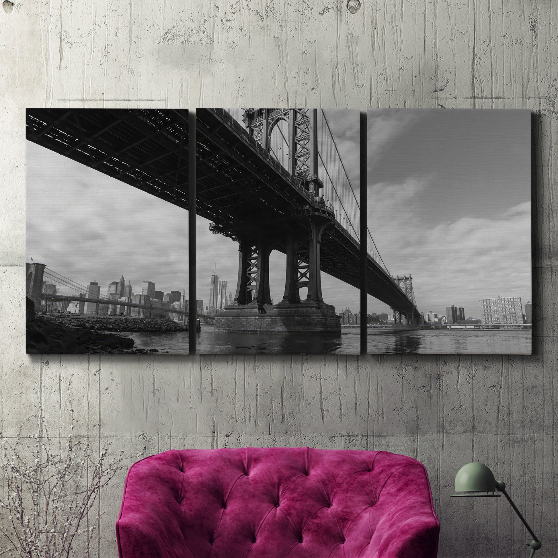 Three-panel canvas wall art featuring manhattan bridge industrial cityscape, displayed in a living room above a suede accent chair.