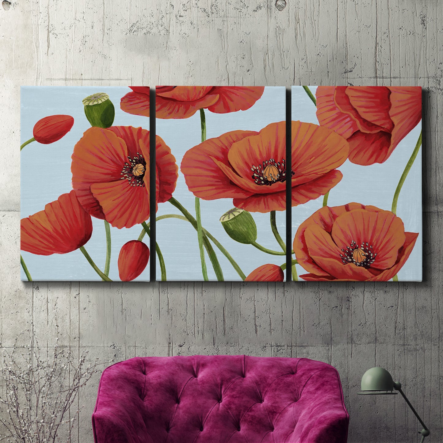 Three-panel canvas wall art featuring red poppies in motion, displayed in a living room above a suede accent chair.