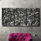 Three-panel canvas wall art featuring energetic expressionist abstract splatter, displayed in a living room above a suede accent chair.