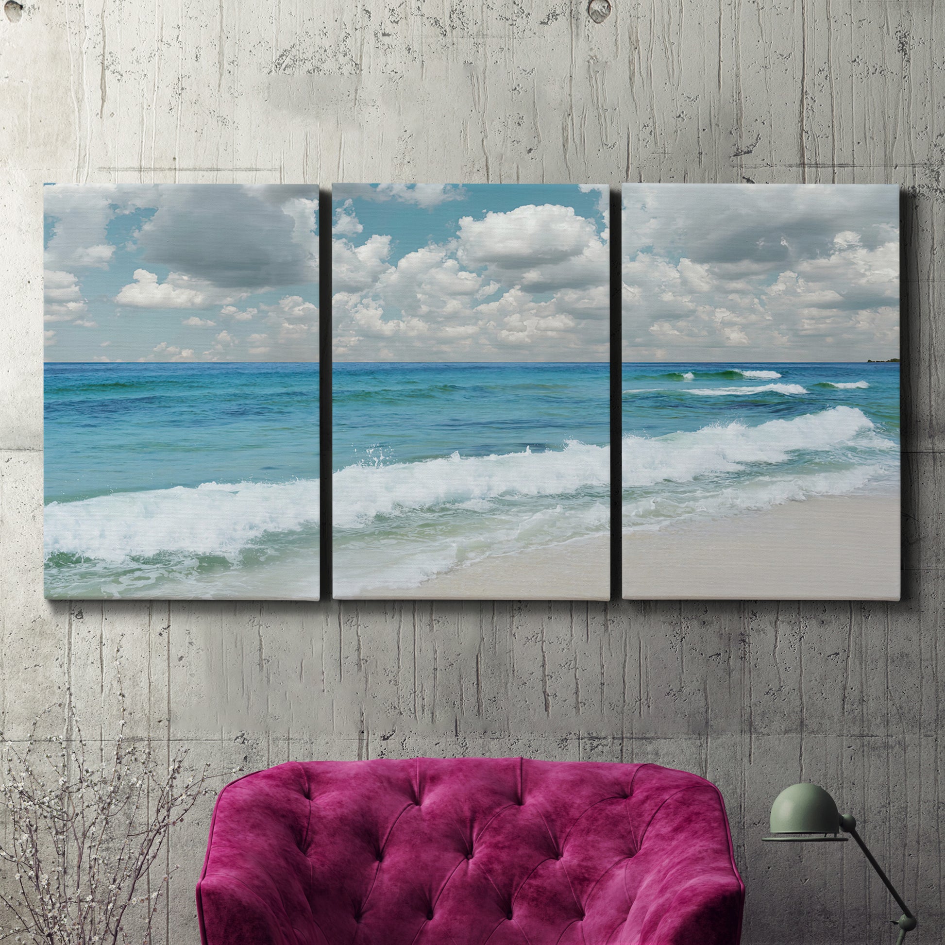 Three-panel canvas wall art featuring tropical beach scene with turquoise water, displayed in a living room above a suede accent chair.