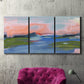 Three-panel canvas wall art featuring sunset reflections across calm sea, displayed in a living room above a suede accent chair.