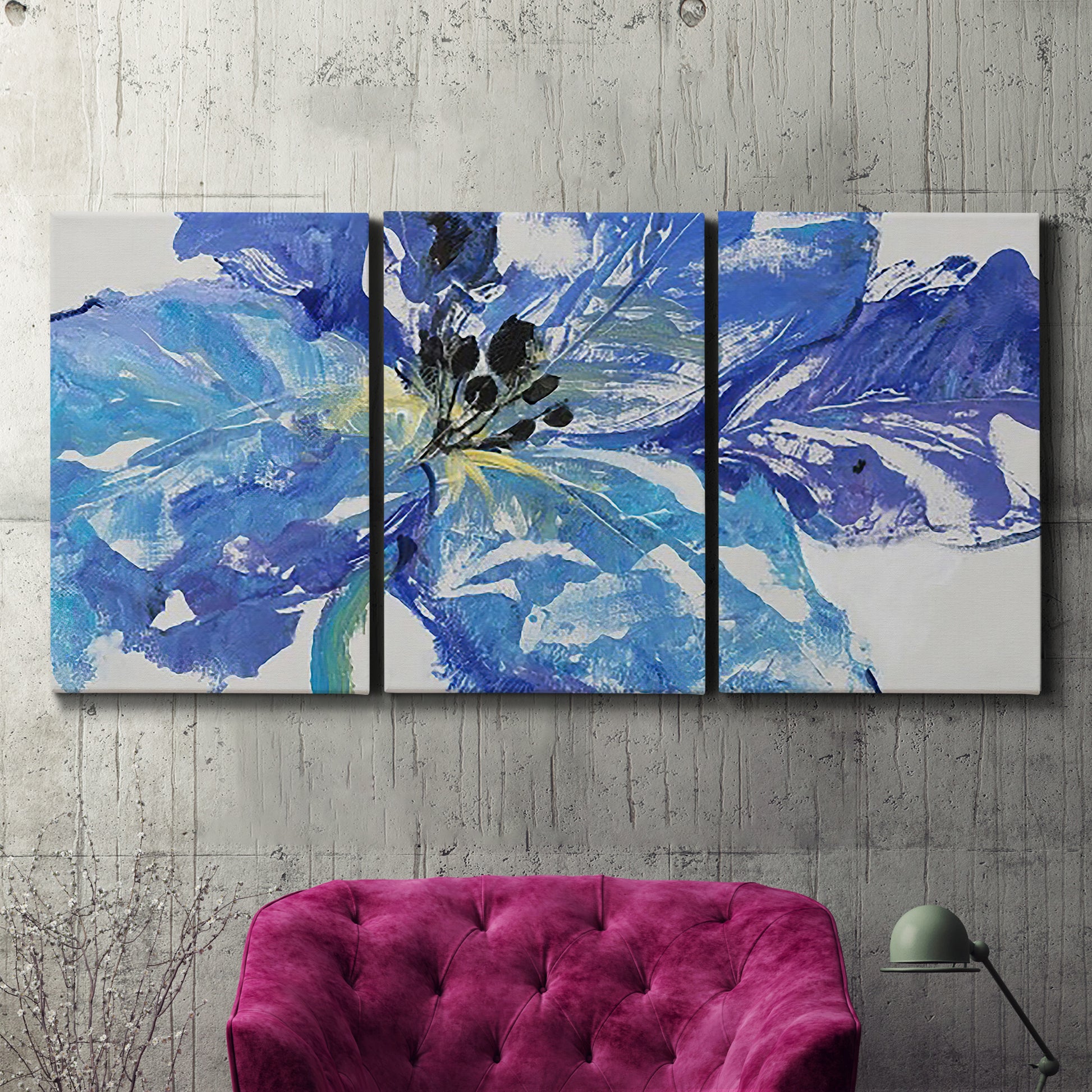 Three-panel canvas wall art featuring blue floral botanical close up, displayed in a living room above a suede accent chair.
