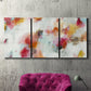 Three-panel canvas wall art featuring abstract directional visual shift, displayed in a living room above a suede accent chair.
