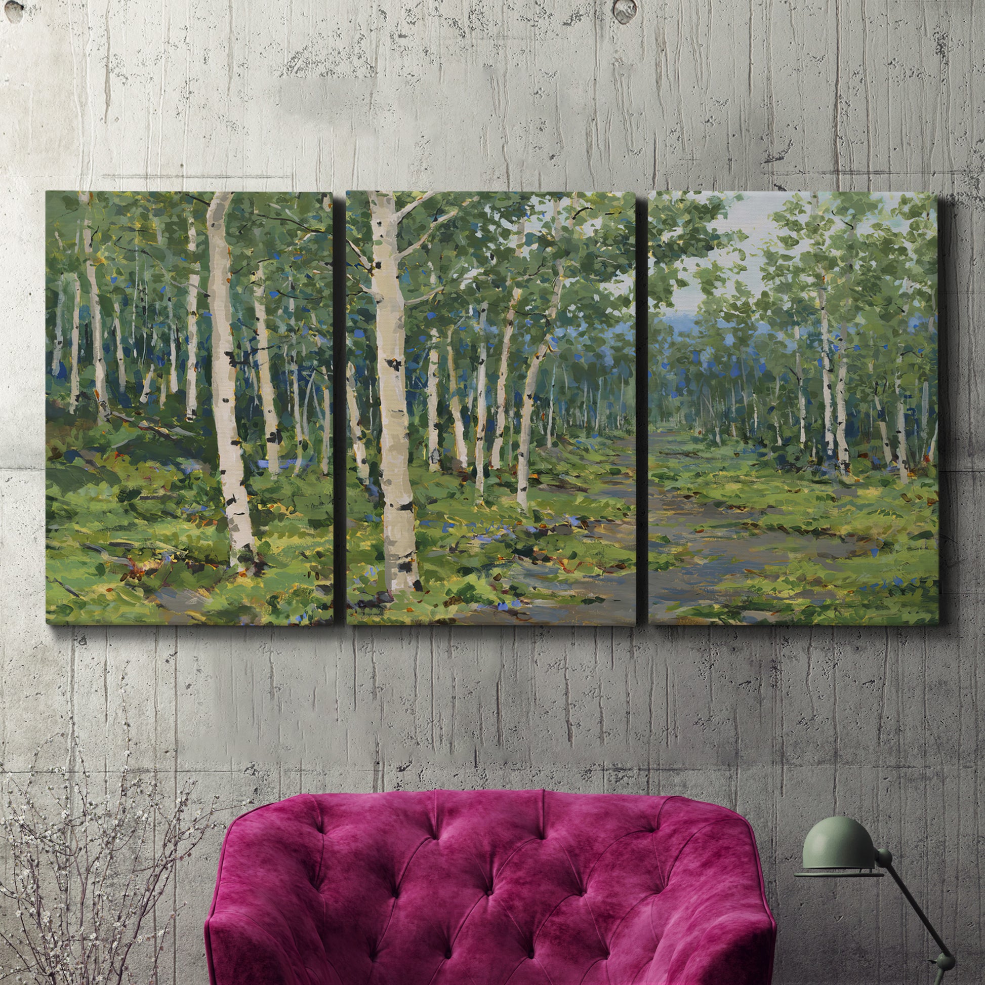 Three-panel canvas wall art featuring woodland forest scene with tall trees, displayed in a living room above a suede accent chair.
