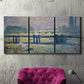 Three-panel canvas wall art featuring london bridge crossing wide river, displayed in a living room above a suede accent chair.