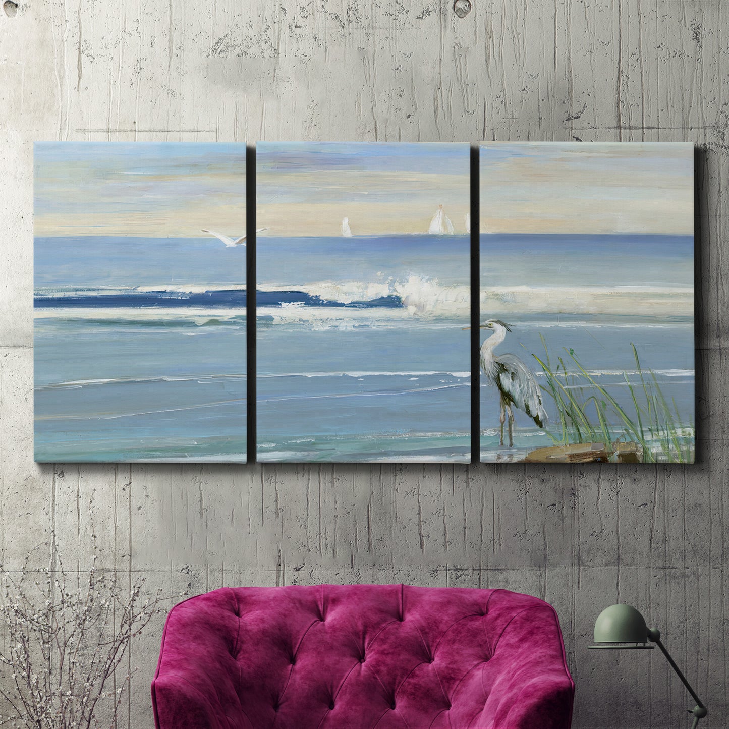 Three-panel canvas wall art featuring sunrise reflecting across bay waters, displayed in a living room above a suede accent chair.