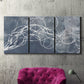 Three-panel canvas wall art featuring coastal shoreline at golden hour, displayed in a living room above a suede accent chair.