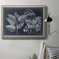 Decorative botanical foliage drawing on navy background in an ornate vintage silver frame displayed in a neutral interior setting.