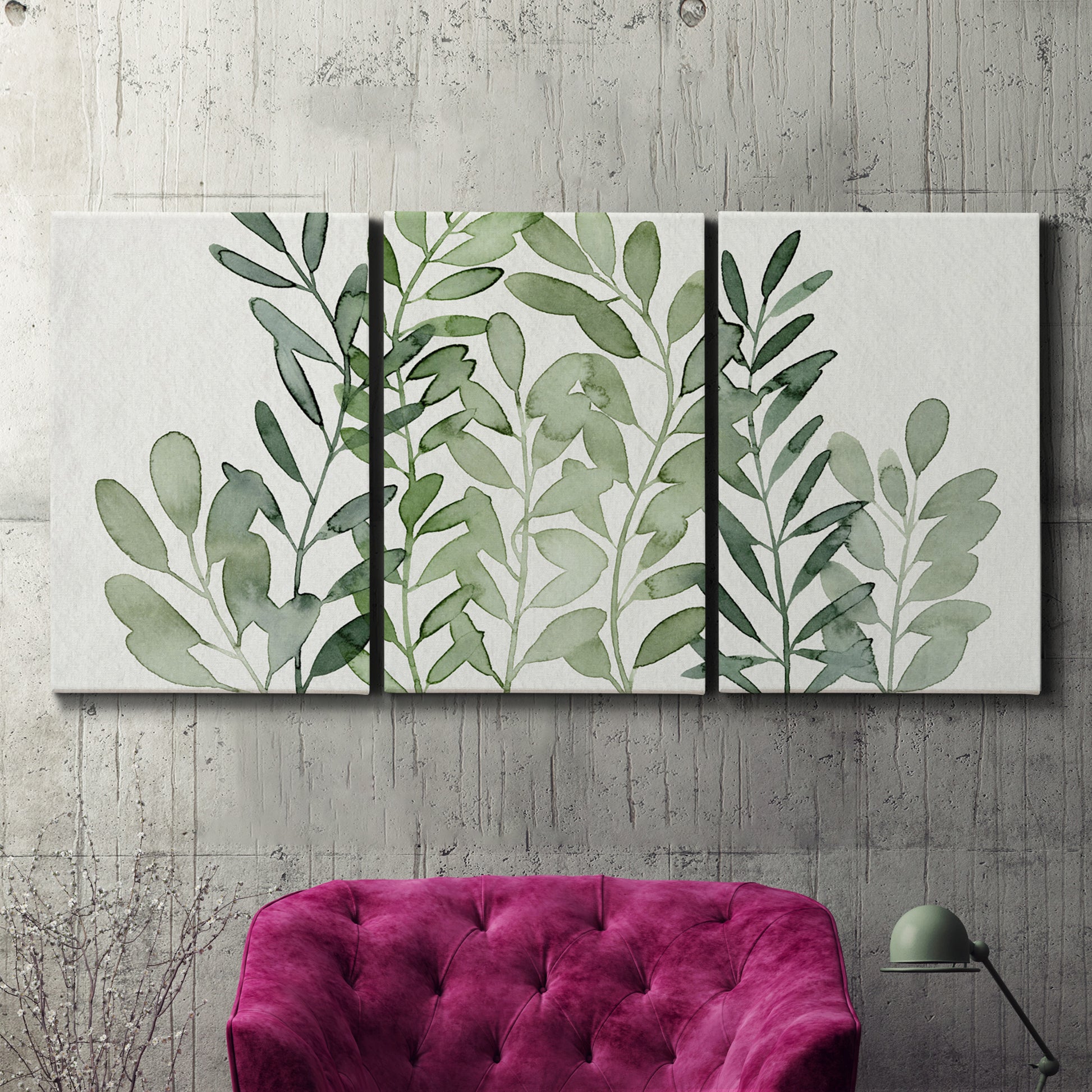 Three-panel canvas wall art featuring foraged leafy greens botanical study, displayed in a living room above a suede accent chair.