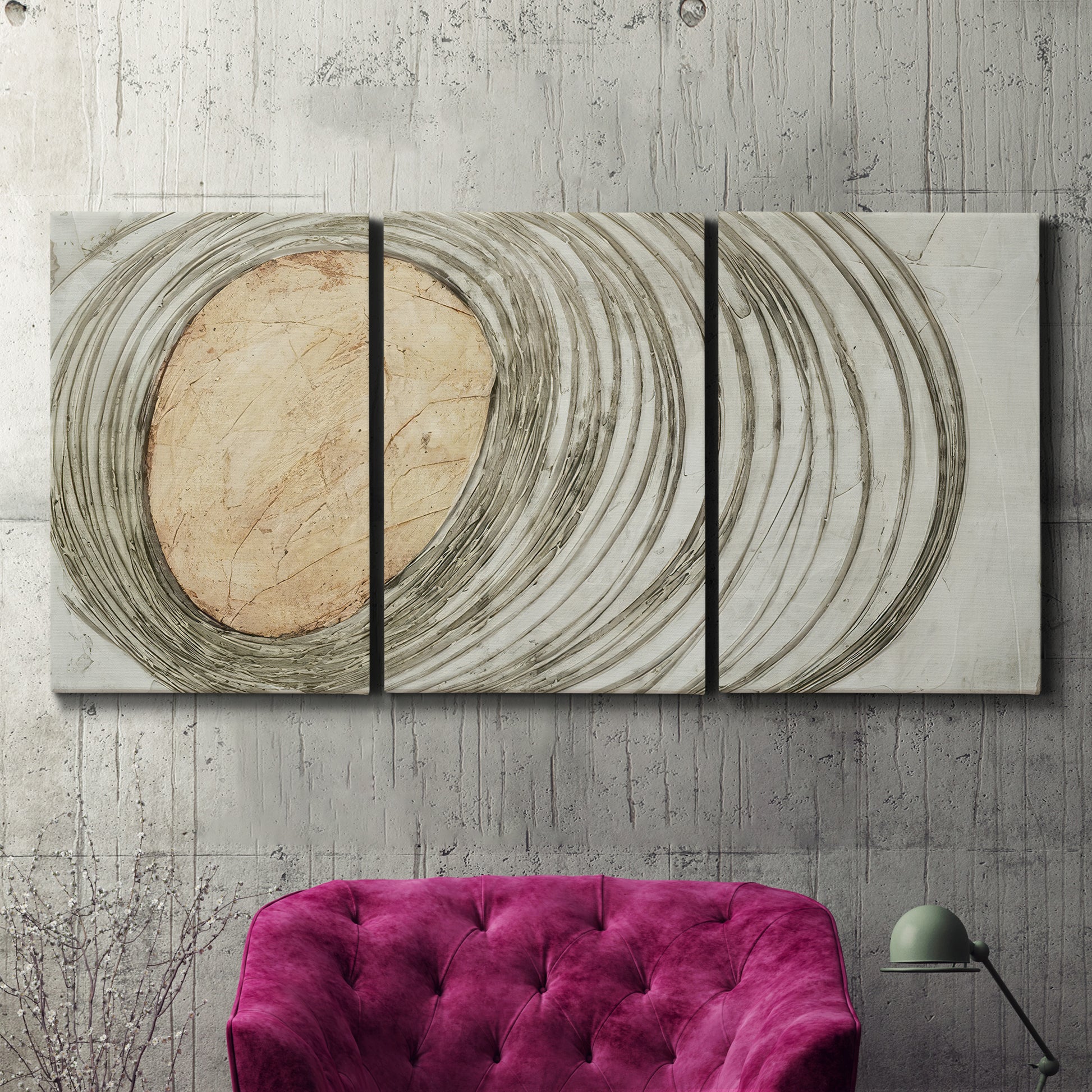 Three-panel canvas wall art featuring circular abstract energy forms, displayed in a living room above a suede accent chair.