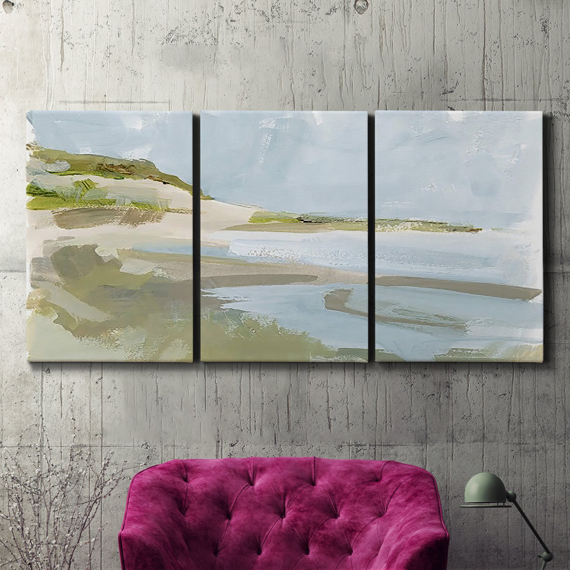 Three-panel canvas wall art featuring coastal cove with calm water, displayed in a living room above a suede accent chair.