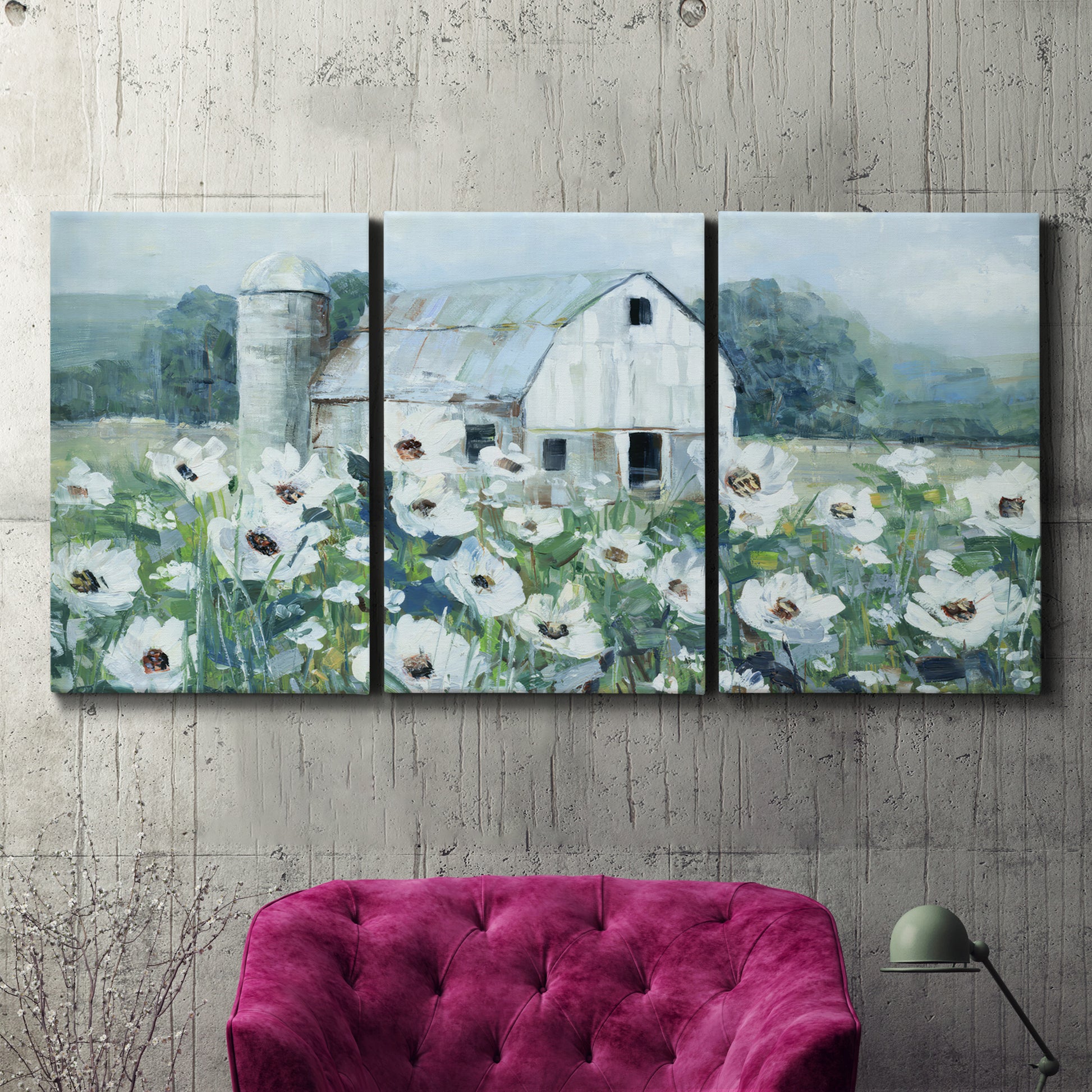 Three-panel canvas wall art featuring pastoral farmland with open fields, displayed in a living room above a suede accent chair.