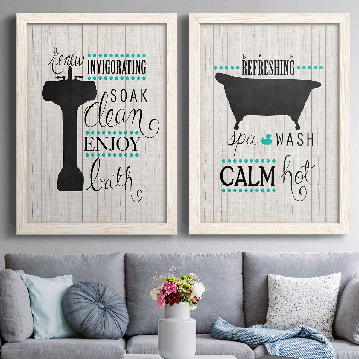 Set of two white barnwood framed canvas prints depicting paired graphic bathroom word art with black tubs, hand-lettered phrases, and small teal accents above a sofa in a contemporary living room.
