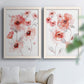 Set of two white barnwood framed canvas prints depicting transparent petals, soft splashes, and abundant white space arranged across two complementary compositions above a sofa in a bright living space.