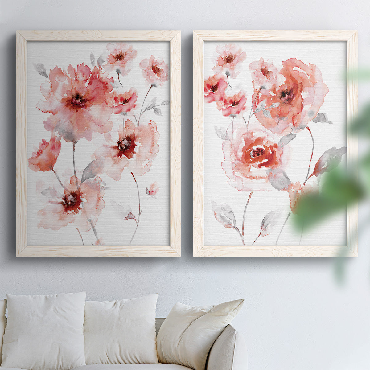 Set of two white barnwood framed canvas prints depicting transparent petals, soft splashes, and abundant white space arranged across two complementary compositions above a sofa in a bright living space.