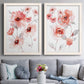 Set of two white barnwood framed canvas prints depicting paired airy contemporary watercolor florals with transparent petals, soft splashes, and abundant white space above a sofa in a contemporary living room.