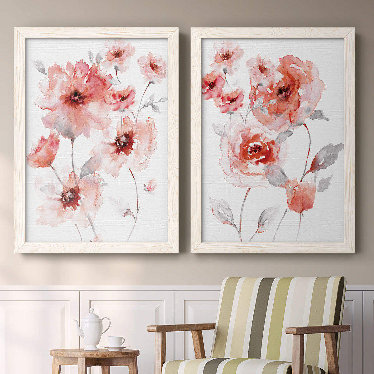 Set of two white barnwood framed canvas prints depicting two airy contemporary watercolor florals featuring loose coral pink blossoms on slender gray stems above a sideboard in a cozy sitting room.