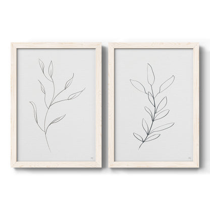 Set of two white barnwood framed canvas prints featuring two minimalist botanical line drawings featuring single continuous-line leafy branches.