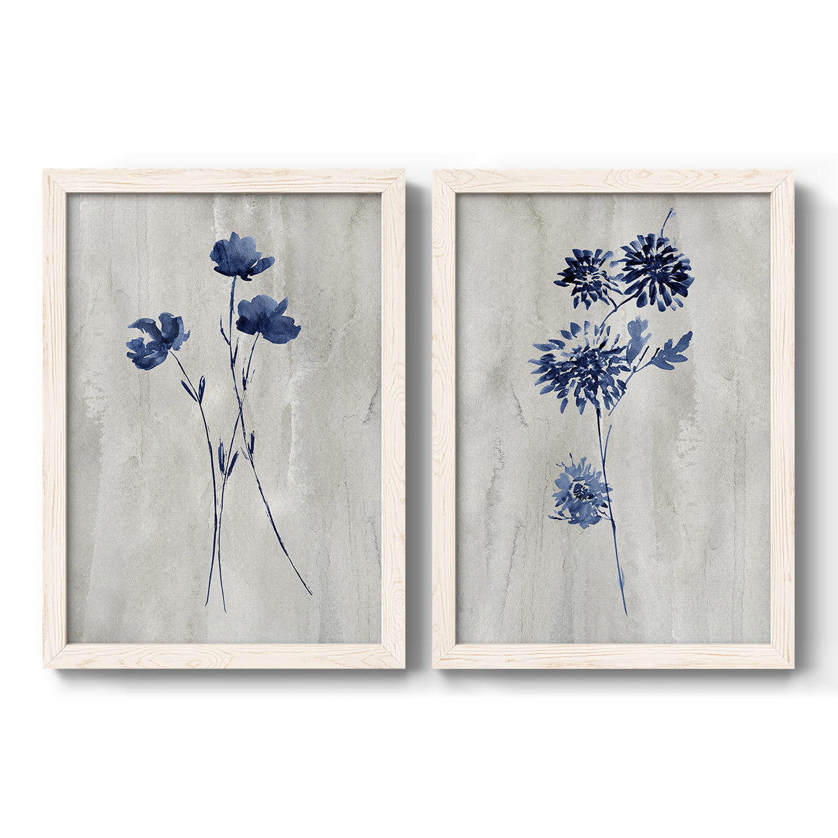 Set of two white barnwood framed canvas prints featuring two rustic monochrome botanical paintings featuring blue wildflower stems on weathered neutral paper.