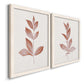 Angled view of a set of two white barnwood framed canvas prints featuring two minimalist botanical prints featuring single rust-red leafy stems.