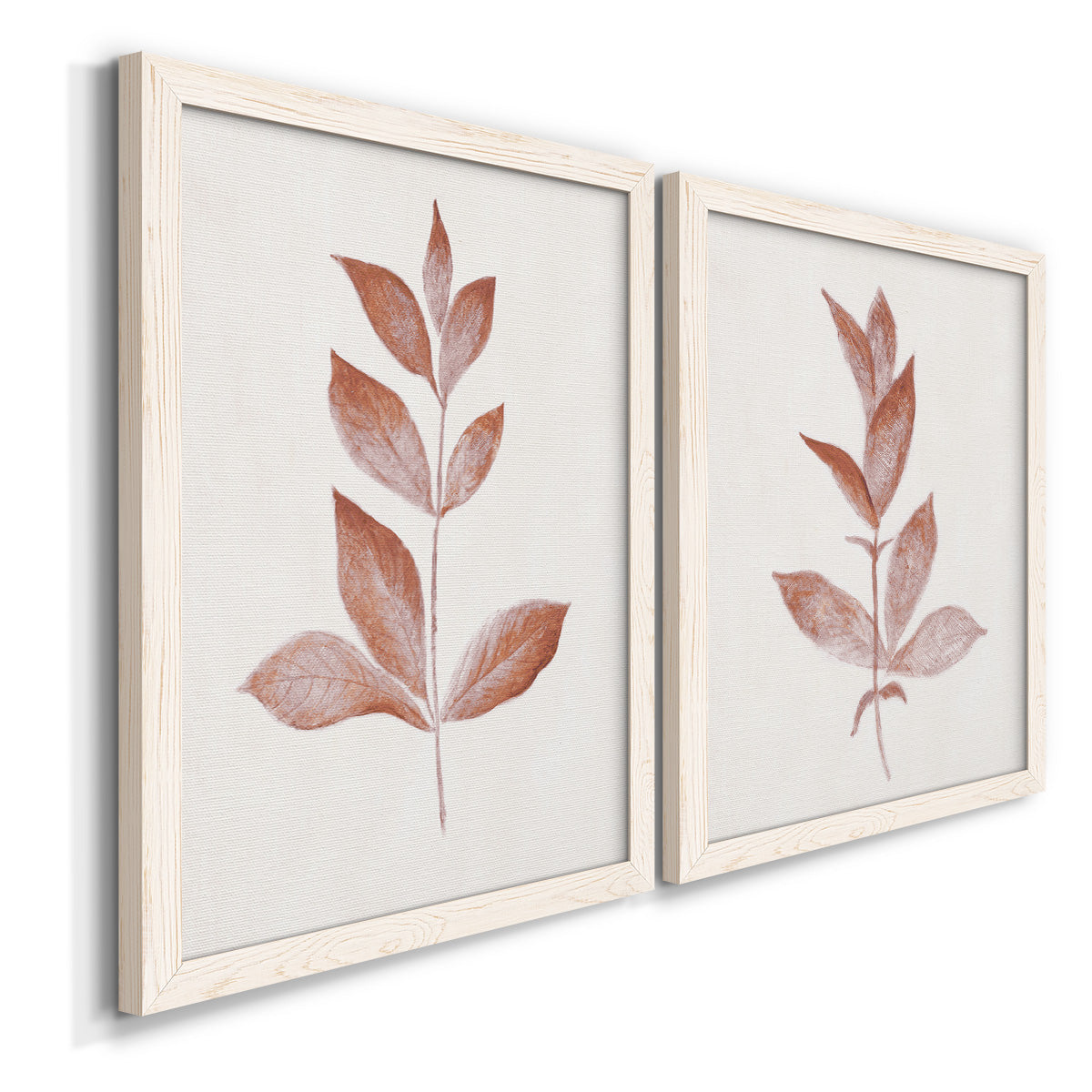 Angled view of a set of two white barnwood framed canvas prints featuring two minimalist botanical prints featuring single rust-red leafy stems.